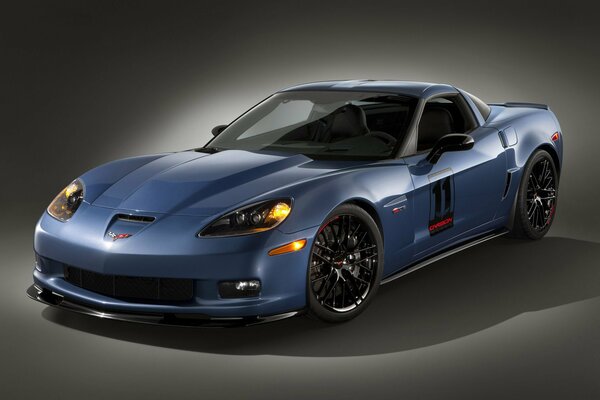 Blue corvette with headlights on