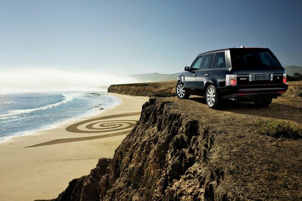 SUV on the mountain on the background of the beach and the sea