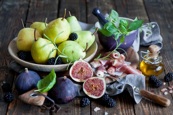 Peras, higos y moras en una mesa de madera