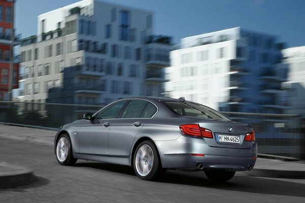 Une voiture BMW grise parcourt la ville