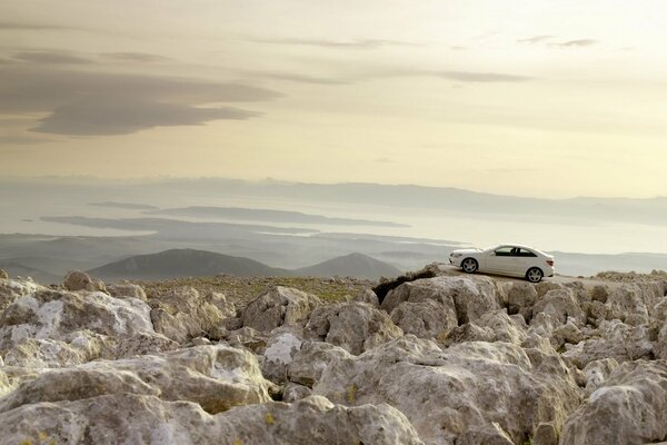 Mersedes stands on a high ledge among rocky terrain and mountains