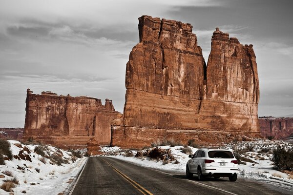 A white Audi rushes along a snowy road