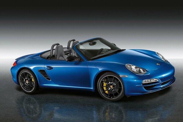 Blauer Porsche Boxster auf grauem Hintergrund