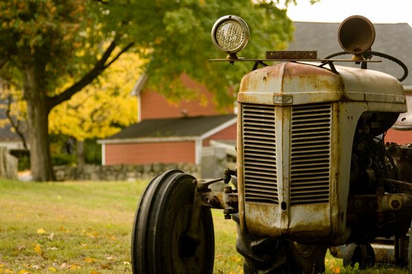 Alter rostiger Traktor im Herbsthintergrund