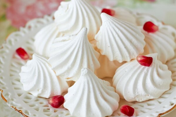 Assiette de meringues tendres et appétissantes avec des grains de Grenade