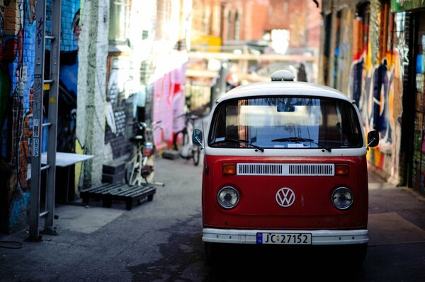 Fourgon rouge Volkswagen sur une rue étroite de la ville