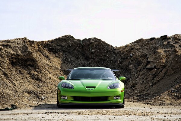 Chevrolet sportiva verde su uno sfondo di terrapieno