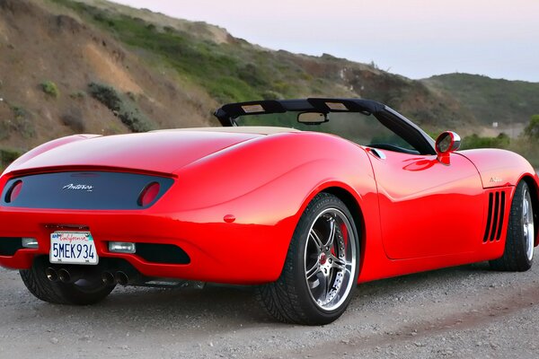 Cabriolet rouge sur un chemin de terre