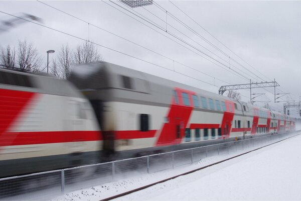 Piętrowy pociąg pędzi z dużą prędkością zimą
