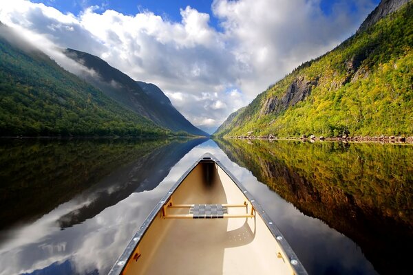 A river surrounded by mountains all around and a blue sky