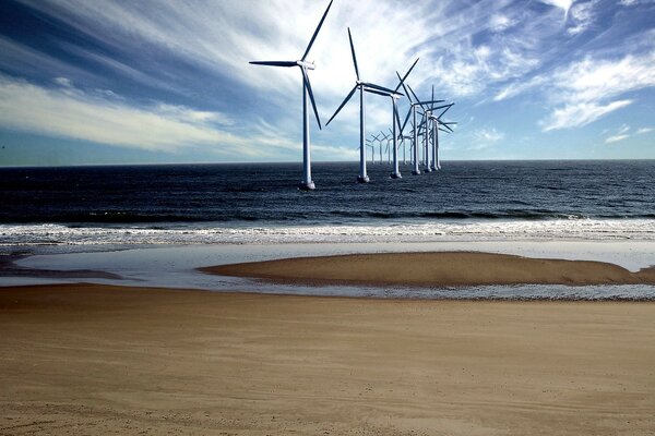 Molino de viento marino en la costa de arena