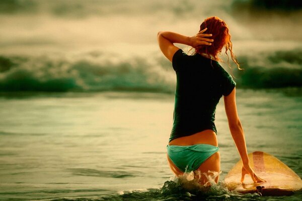 Chica con pelo rojo y olas de surf