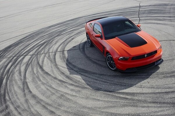 Voiture orange avec toit noir en dérapage