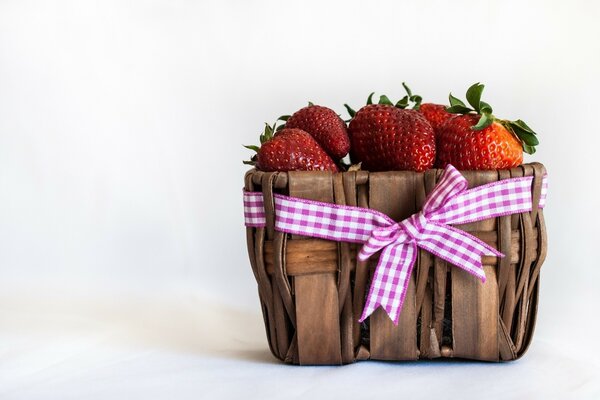 There is a basket with strawberries on a white background