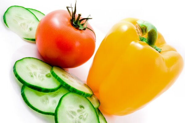 Vegetables cucumbers tomatoes and peppers on a white background