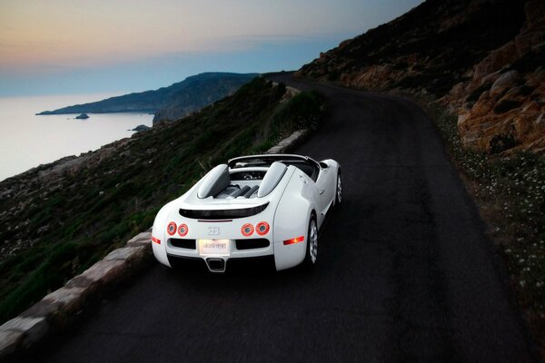 On the night road along the sea in a sports car