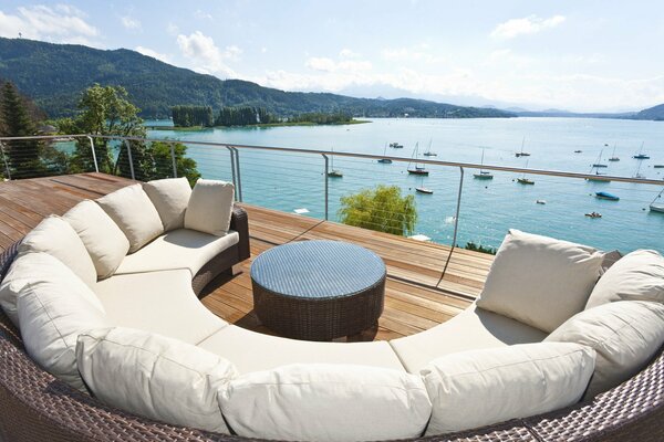 Canapé confortable semi-circulaire sur la terrasse avec vue sur le lac