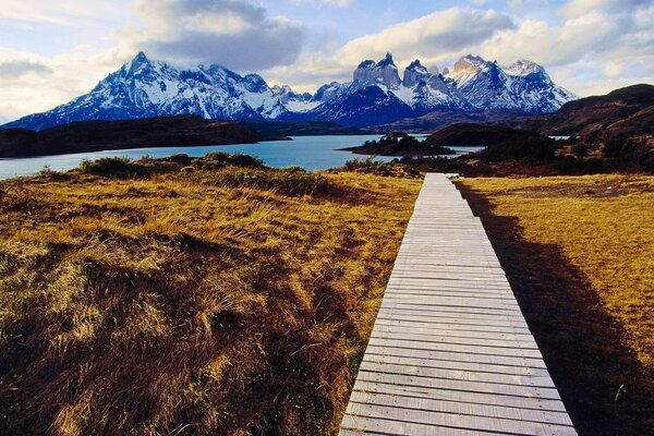 Sentiero di legno verso le montagne e il lago