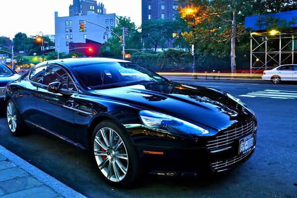 A black sparkling aston martin on a city road