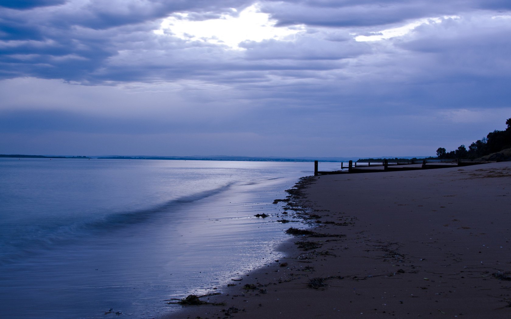 piliers crépuscule mer sable nuages