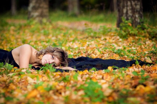 Beautiful brown-haired woman in a black dress in the forest