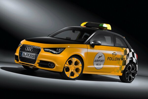 Yellow audi a1 wortherse 981 in beautiful lighting and with the airport logo