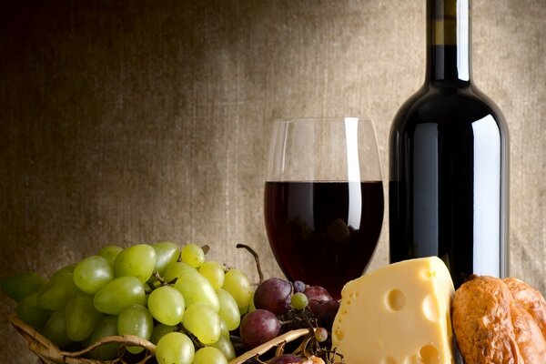 A bottle of wine cheese and grapes