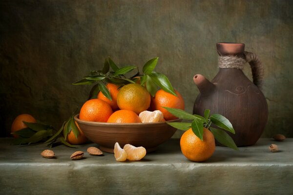Still life: oranges in a cup and a jug