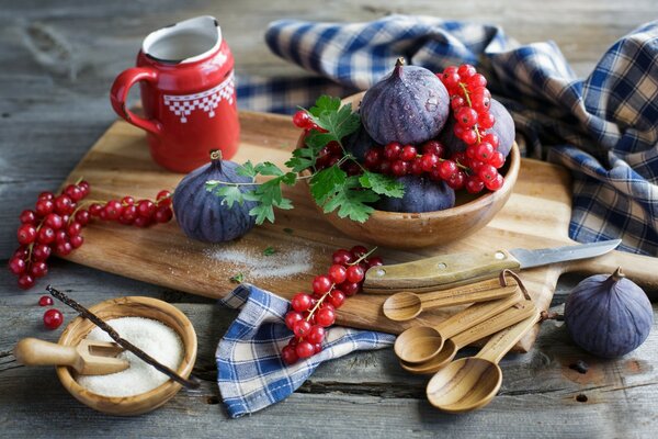 Groseilles rouges sur une planche avec du sucre et des figues