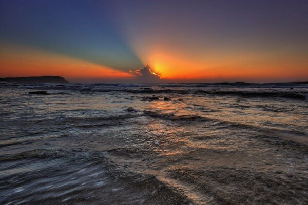 Heller Sonnenuntergang aus den Wolken ins Meer