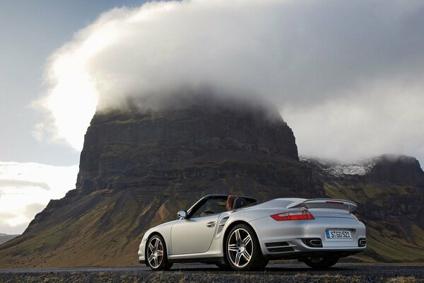 Cabriolet sur fond de nature avec des montagnes et des nuages