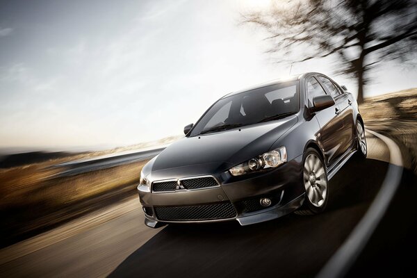 Lancer Mitsubishi evolution x en el fondo de una foto borrosa de la carretera