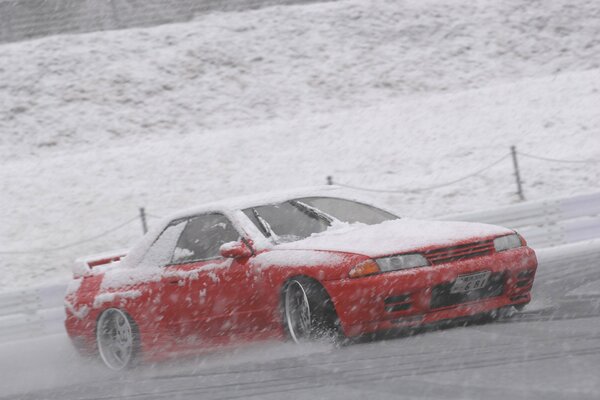 Nissan en la carretera a la velocidad en la nieve