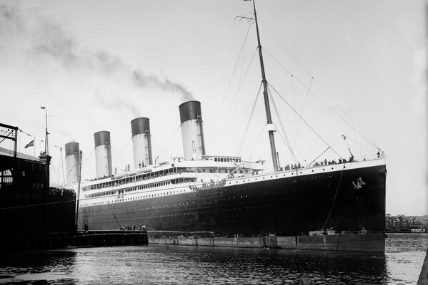 A large ship departs from the harbor