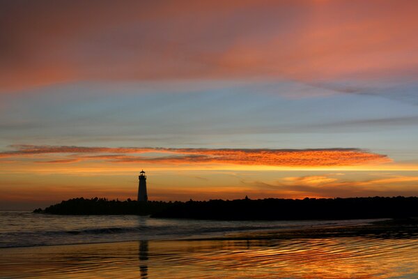 Phare sur le fond d un ciel orange inondé de coucher de soleil se reflète dans l eau