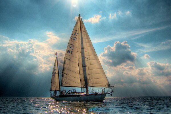 Ein Segelboot schwimmt auf einem unruhigen Meer vor dem Hintergrund eines bewölkten Himmels