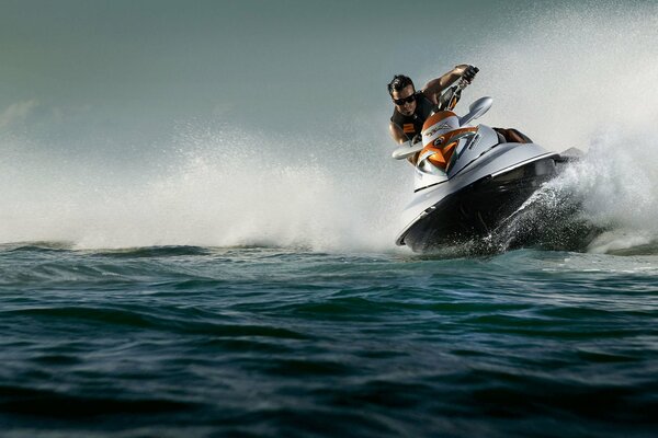The jet ski cuts through the waves as much as splashes fly to the sides