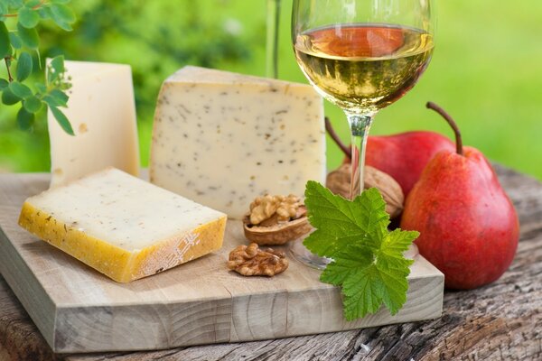 Käsescheiben auf einer Tafel mit Weißwein