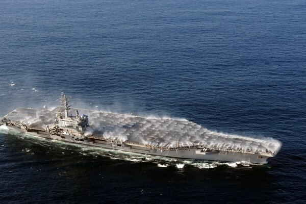 The aircraft carrier rushes across the bottomless ocean