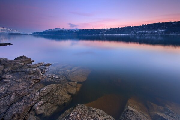 Górskie jezioro przy różowym zachodzie słońca