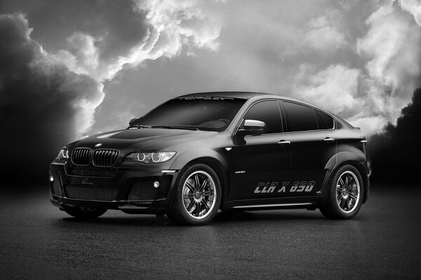 Black and white photo of a BMW on a background of clouds