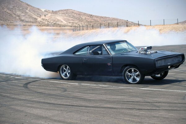 Dodge Charger in skid con una nuvola di scarico