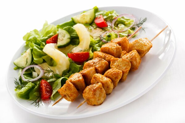 Shish kebab avec salade sur fond blanc