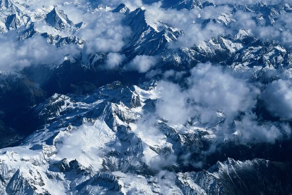 Montagne innevate con nuvole bianche