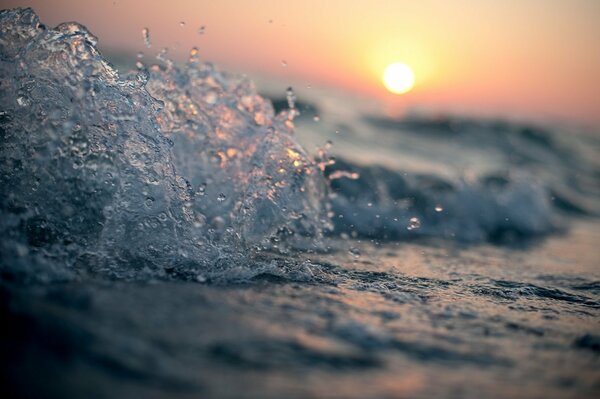 Éclaboussure d eau en gros plan sur fond de coucher de soleil