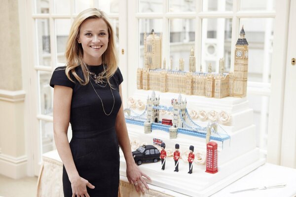 Reese Witherspoon dans une robe noire et une table avec des maquettes