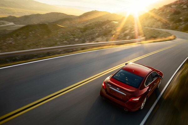 Nissan Maxima sur la serpentine de montagne. Coucher du soleil