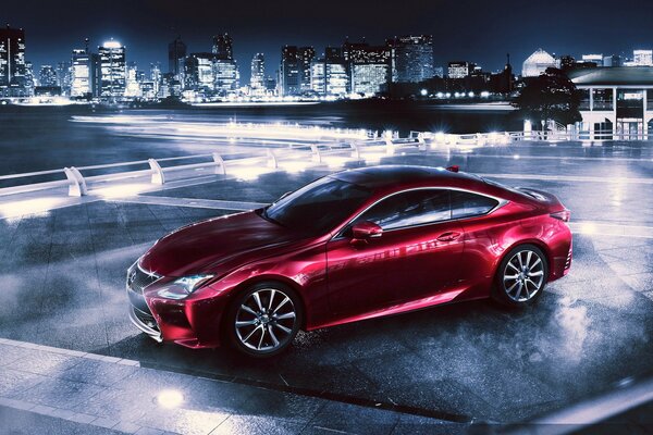 Red Lexus rc 350 at night on the background of the metropolis