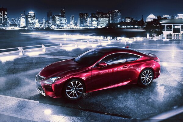 Lexus RC 350 rossa di notte sullo sfondo di una metropoli