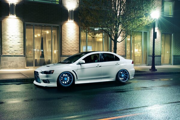 Mitsubishi Lancer blanc dans la rue du soir